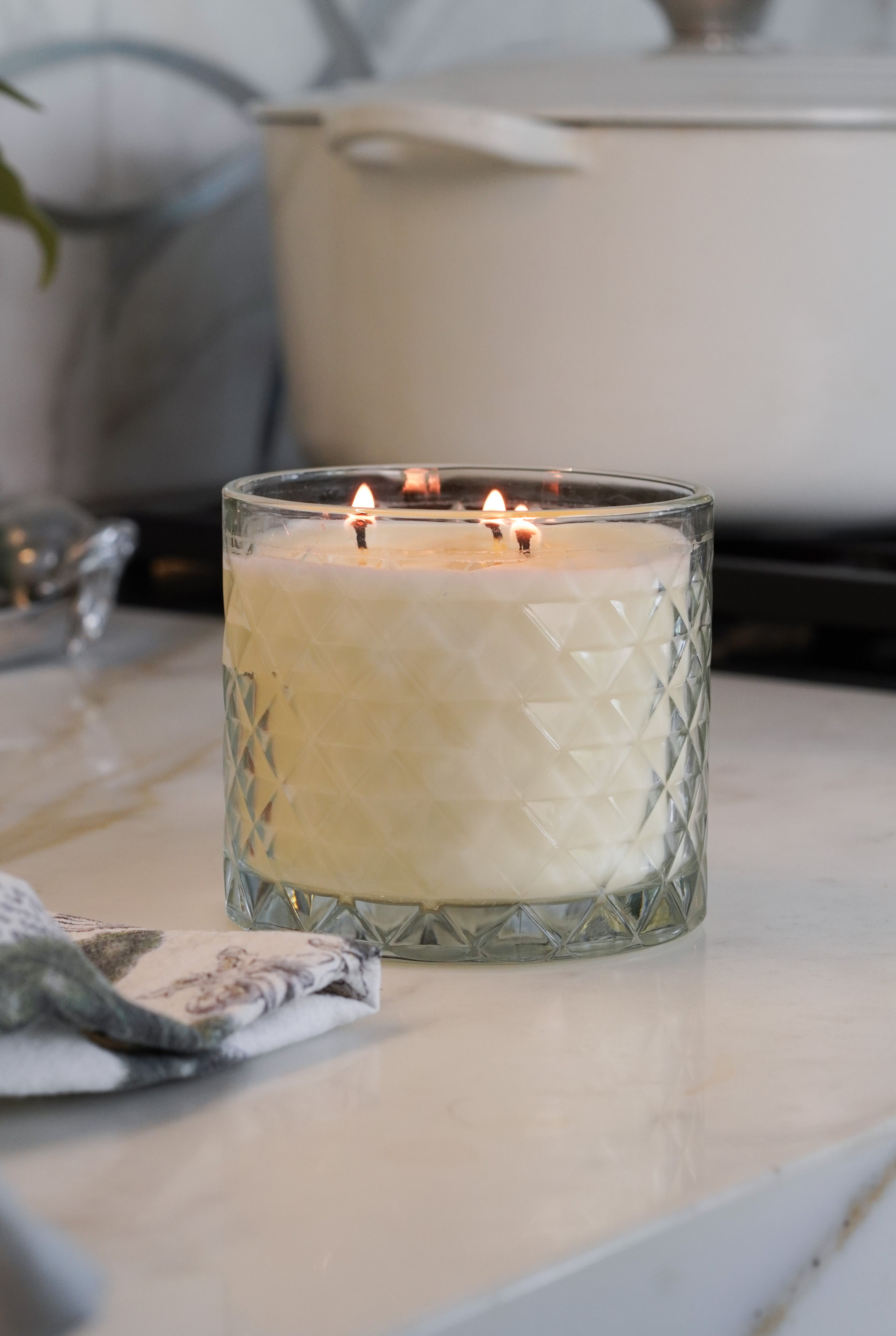 Clean sheets candle burns in kitchen.